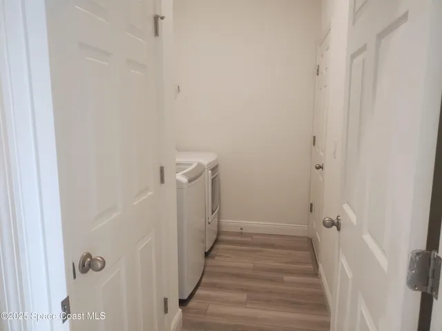 a view of a hallway with wooden floor and entryway
