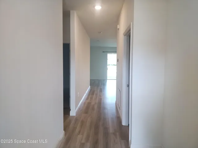 a view of a hallway with wooden floor