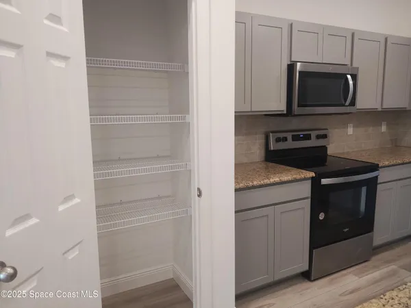 a kitchen with granite countertop cabinets and steel appliances