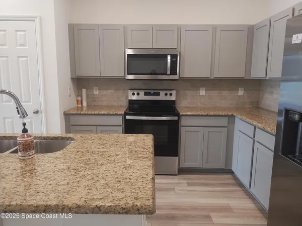 a kitchen with sink a microwave and cabinets