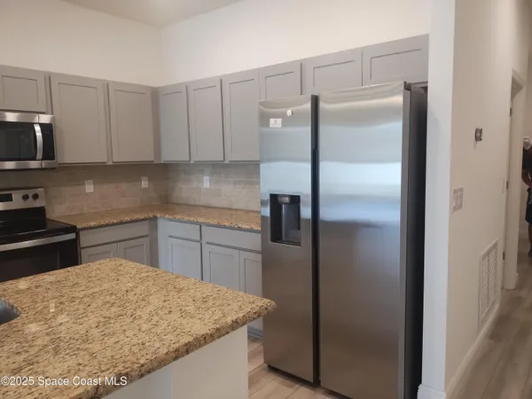 a kitchen with stainless steel appliances granite countertop a refrigerator and a sink