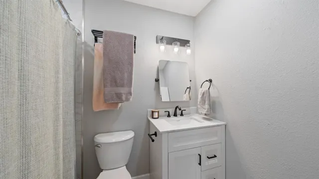 a bathroom with a toilet sink and mirror