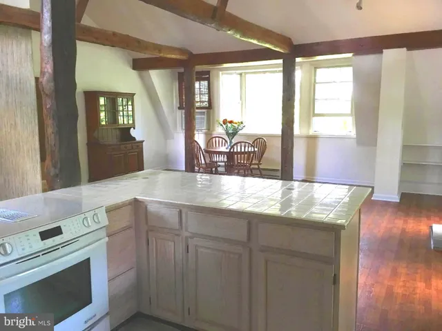 a kitchen with granite countertop a stove a sink and dishwasher with wooden floor