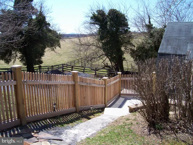 a view of a yard with wooden fence