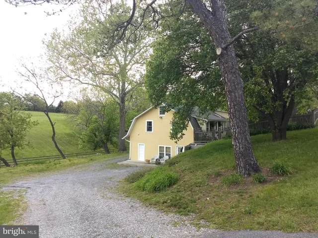 a view of a small house with a tree in the background