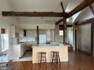 a dining hall with stainless steel appliances kitchen island granite countertop a dining table and chairs