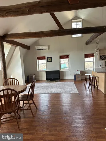 a dining room with furniture wooden floor a rug and a painting