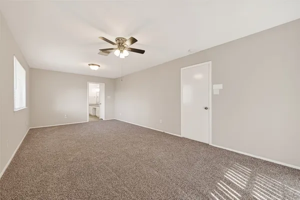 a view of a big room with windows and chandelier fan