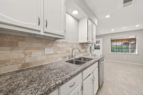 a kitchen with granite countertop a sink and a white stove