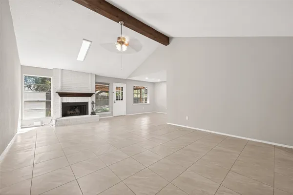 an empty room with windows and fireplace