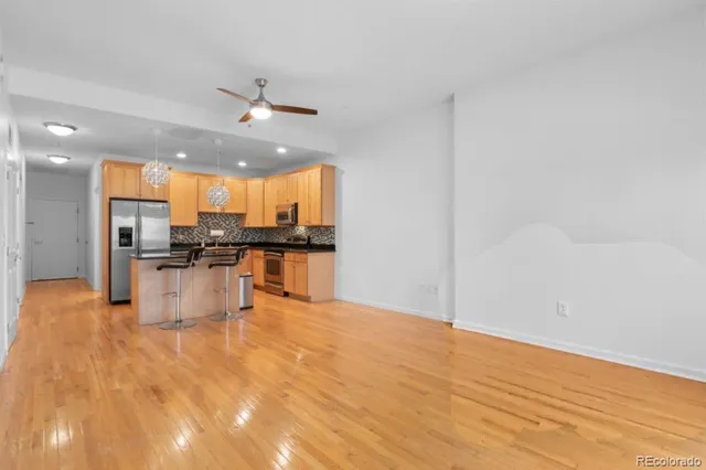a kitchen with stainless steel appliances kitchen island granite countertop a refrigerator and a stove top oven