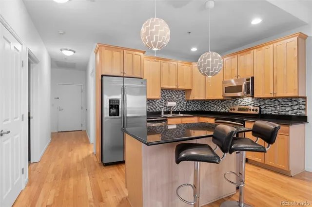 a kitchen with kitchen island granite countertop a sink cabinets and stainless steel appliances