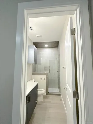 a spacious bathroom with a glass shower door and a sink