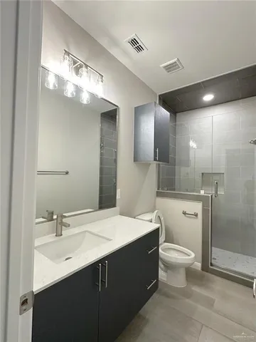 a bathroom with a double vanity sink a toilet and a mirror