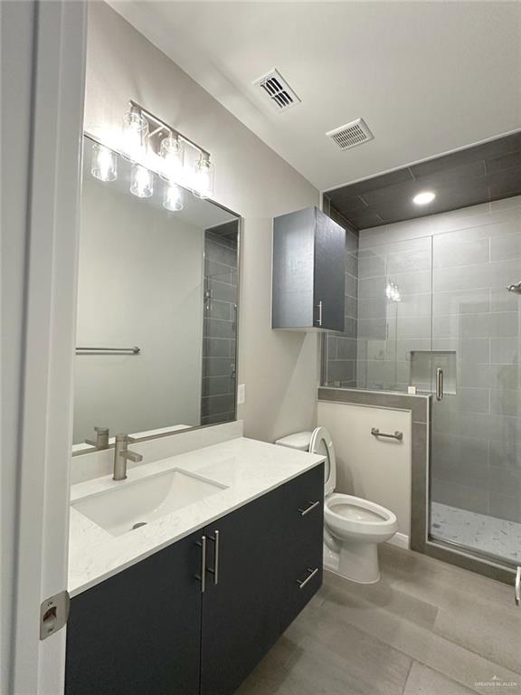5704 Swallow Avenue, Unit 3 McAllen, TX 78573 - Photo 14 of 21 a bathroom with a double vanity sink a toilet and a mirror