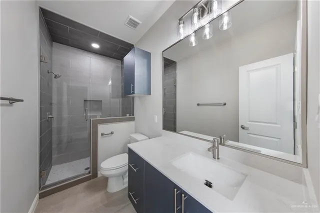 a bathroom with a sink a toilet a mirror and shower