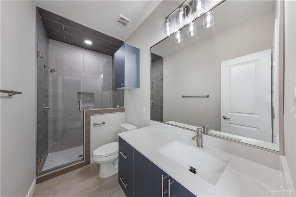 5704 Swallow Avenue, Unit 3 McAllen, TX 78573 - Photo 16 of 21 a bathroom with a sink a toilet a mirror and shower