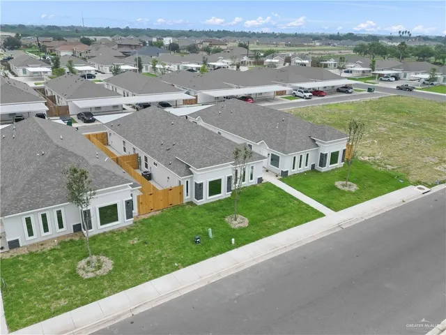 an aerial view of multiple houses with a yard