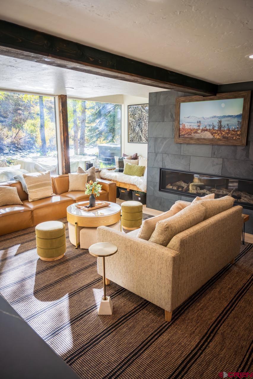 170 Lower Allen Road Crested Butte, CO 81224 - Photo 7 of 42 a living room with fireplace furniture and a large window