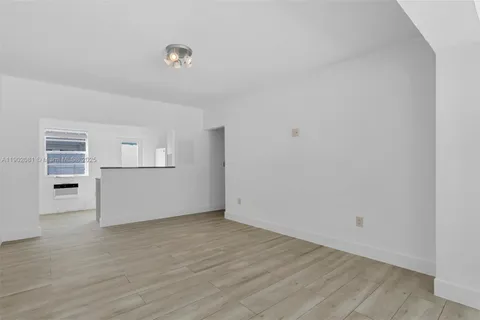 a view of empty room with wooden floor and cabinet