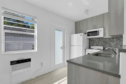 a kitchen with granite countertop a refrigerator and a sink