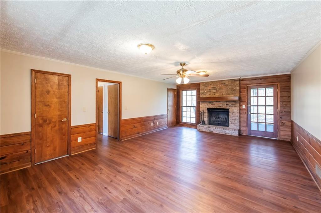 4597 East Glen Ridge Circle Winston, GA 30187 - Photo 11 of 38 an empty room with wooden floor fireplace and windows