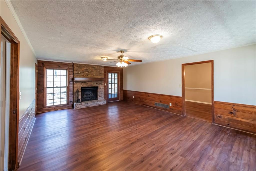 4597 East Glen Ridge Circle Winston, GA 30187 - Photo 12 of 38 an empty room with wooden floor fireplace and windows