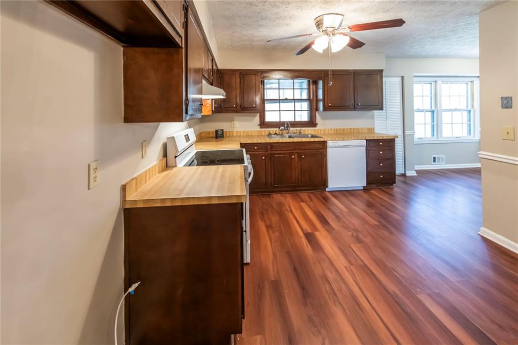 4597 East Glen Ridge Circle Winston, GA 30187 - Photo 16 of 38 a kitchen with a sink dishwasher a stove and a microwave oven with cabinets