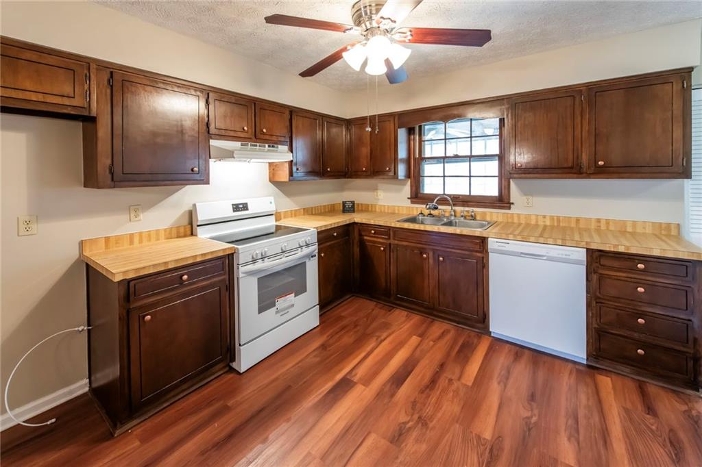 4597 East Glen Ridge Circle Winston, GA 30187 - Photo 17 of 38 a kitchen with stainless steel appliances granite countertop wooden cabinets a sink dishwasher a stove and a refrigerator