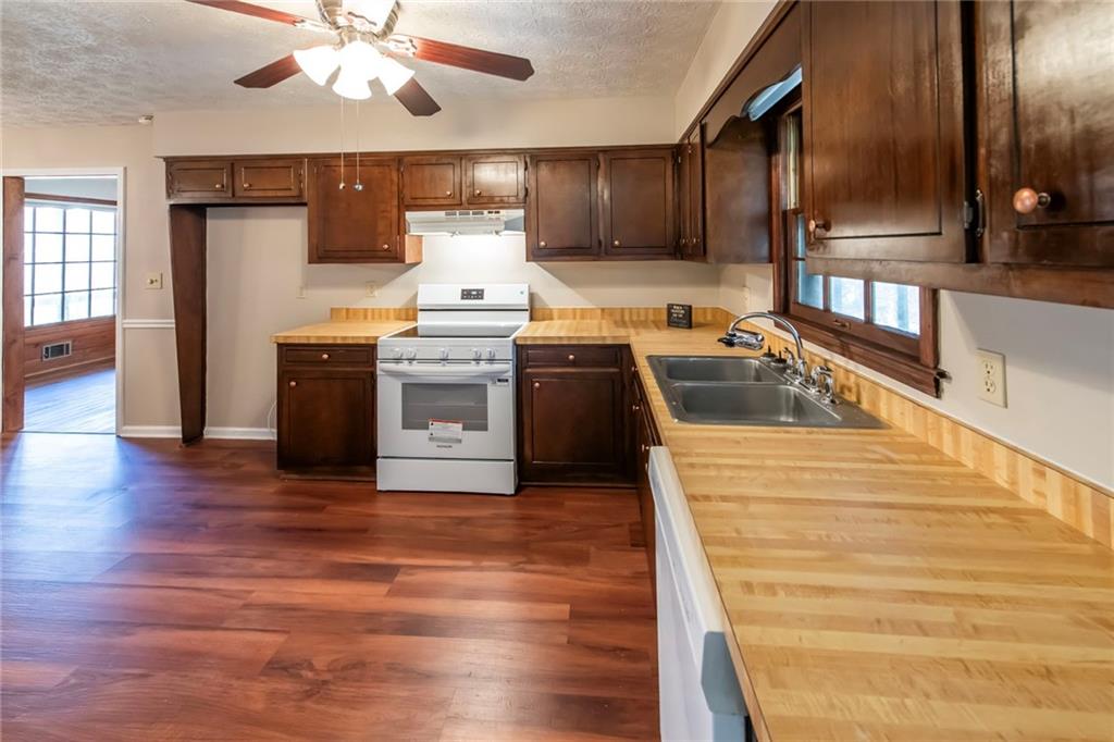 4597 East Glen Ridge Circle Winston, GA 30187 - Photo 18 of 38 a kitchen with wooden floors and stainless steel appliances