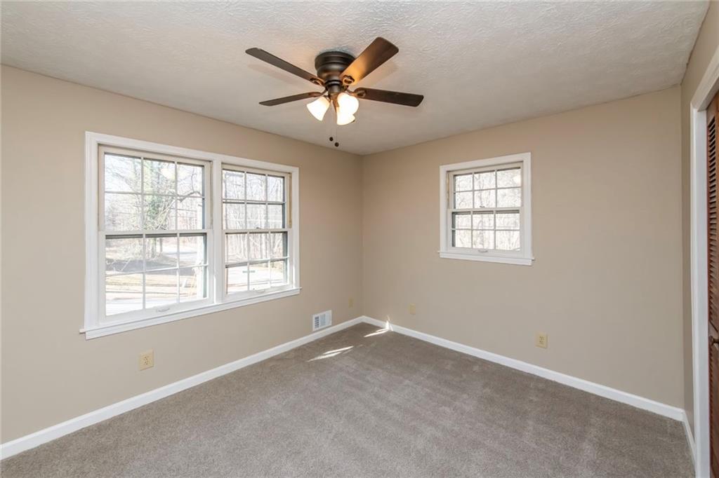4597 East Glen Ridge Circle Winston, GA 30187 - Photo 24 of 38 an empty room with ceiling fan and windows