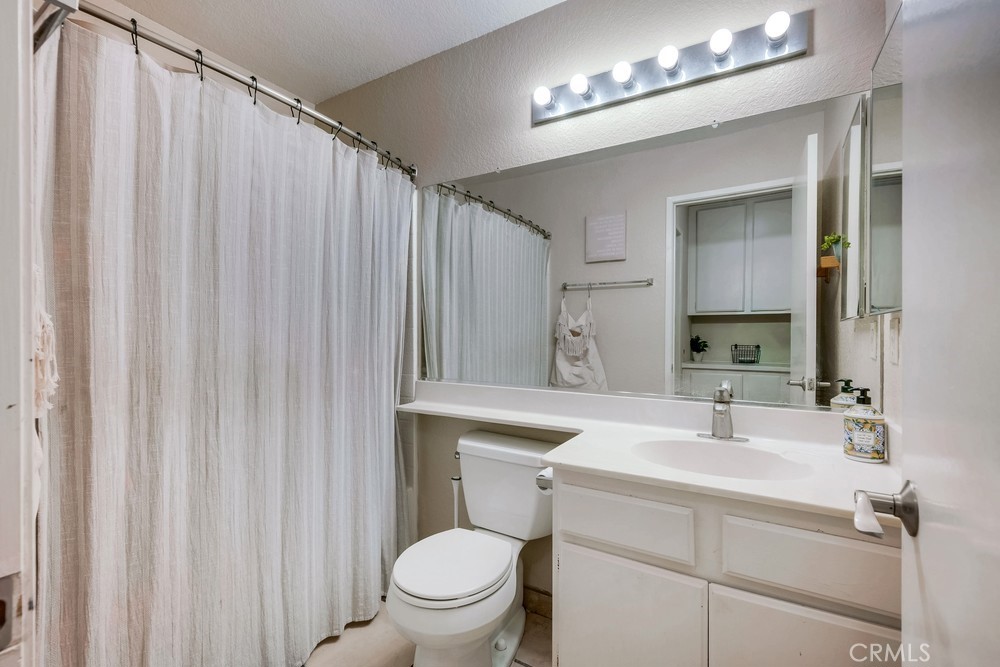930 Countryside Street Hemet, CA 92545 - Photo 31 of 45 a bathroom with a sink a toilet a mirror and shower curtain