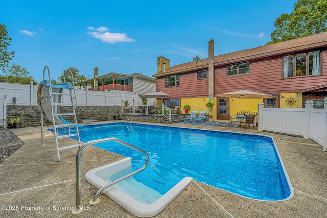 a view of a patio with table and chairs under an umbrella