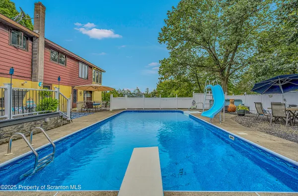 a large hall with dining table and a chandelier