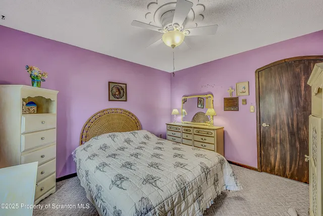 a bedroom with a bed and large windows
