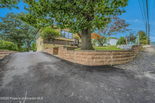 a view of a house with a large tree