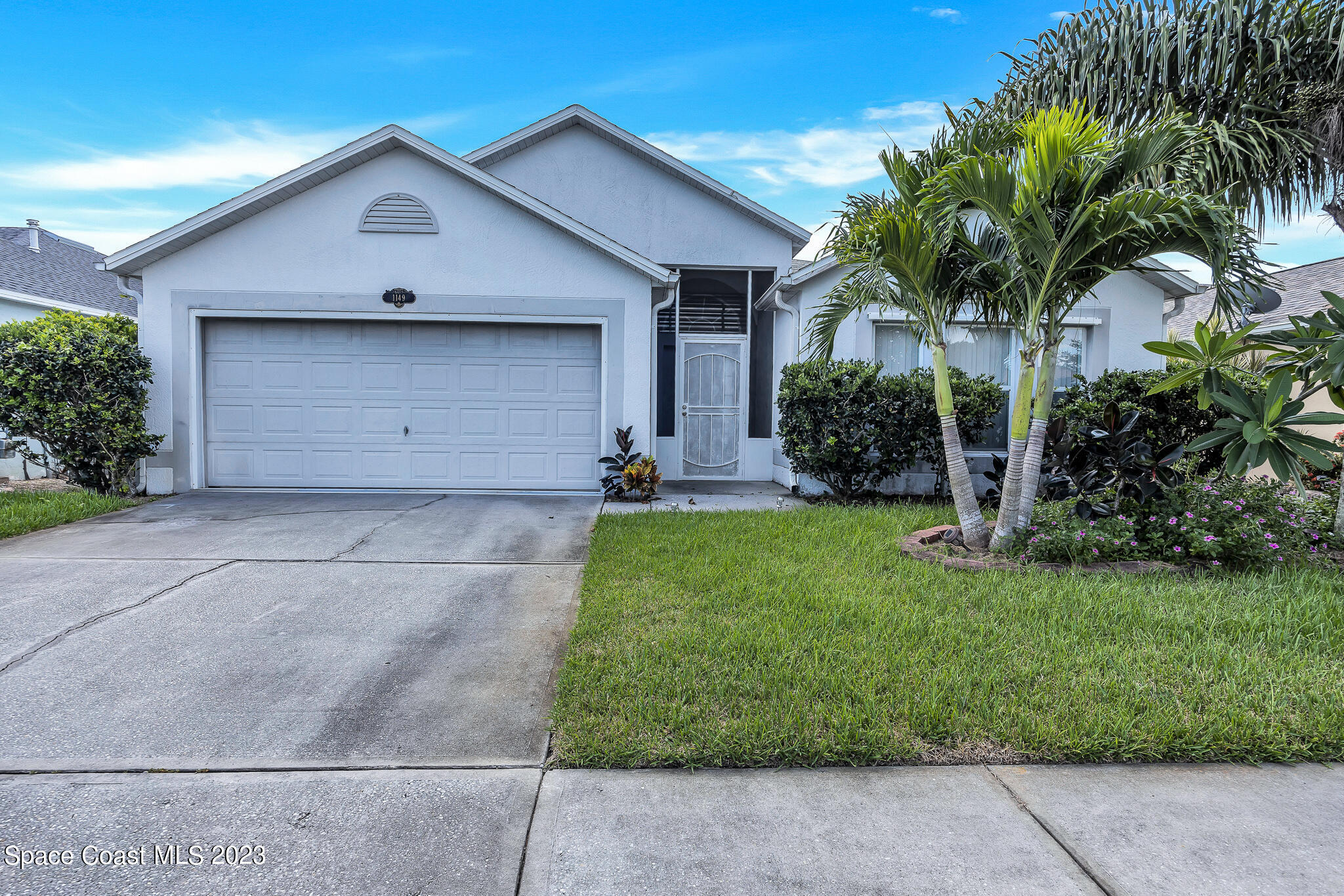 1149 White Oak Circle Melbourne, FL 32934 - Photo 2 of 55 a view of a house with a yard and palm trees