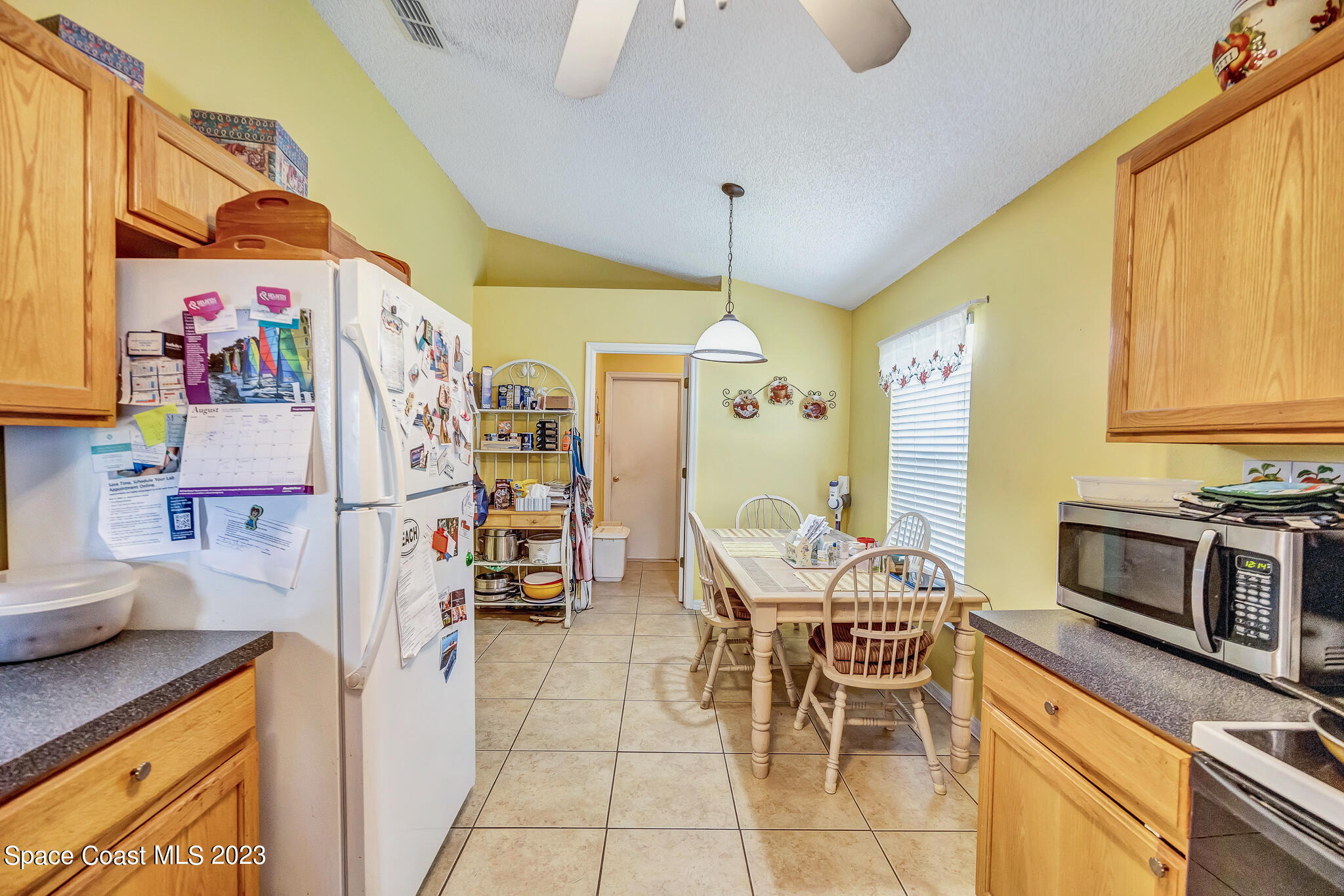 1149 White Oak Circle Melbourne, FL 32934 - Photo 30 of 55 a kitchen with stainless steel appliances kitchen island granite countertop a table and chairs in it