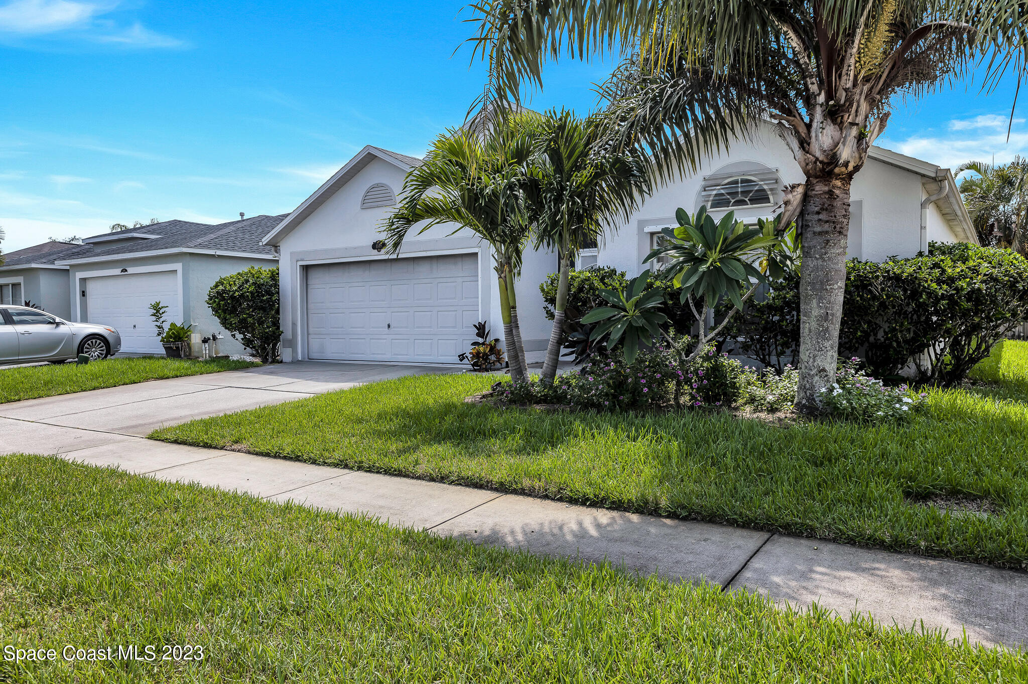 1149 White Oak Circle Melbourne, FL 32934 - Photo 4 of 55 a view of a house with a yard with plants and palm trees