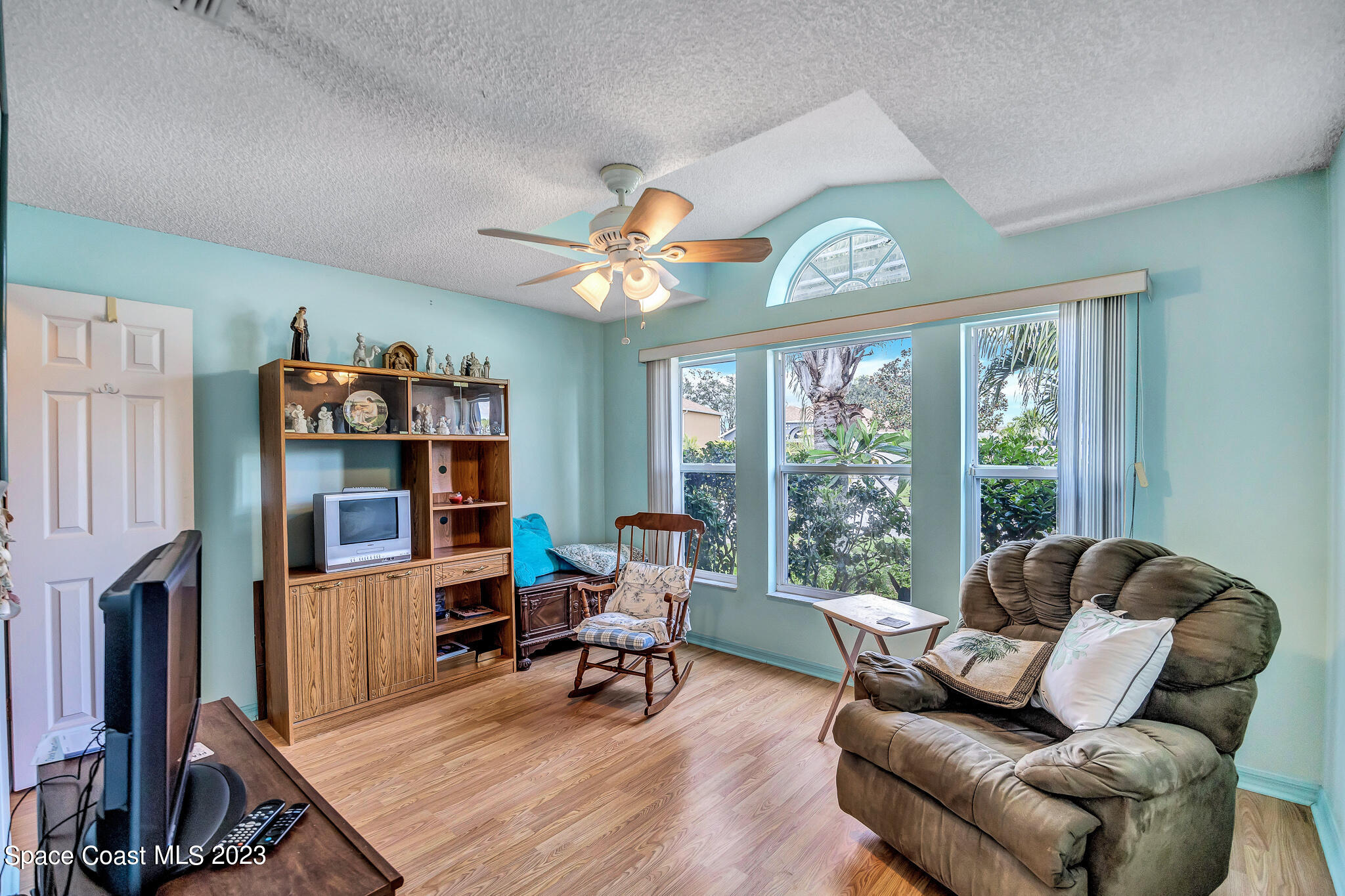 1149 White Oak Circle Melbourne, FL 32934 - Photo 7 of 55 a living room with furniture a flat screen tv and a large window