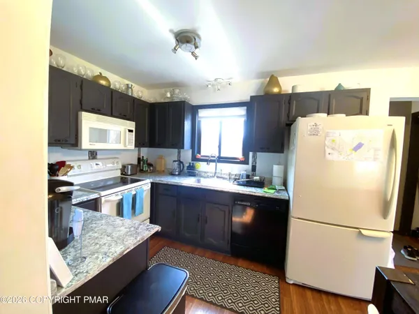 a kitchen with a refrigerator a stove a sink dishwasher and wooden cabinets
