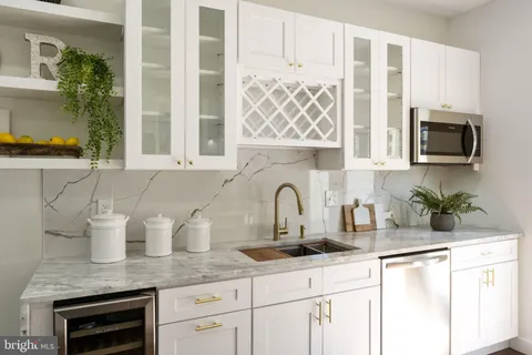 a kitchen with stainless steel appliances granite countertop a sink a microwave a refrigerator and cabinets