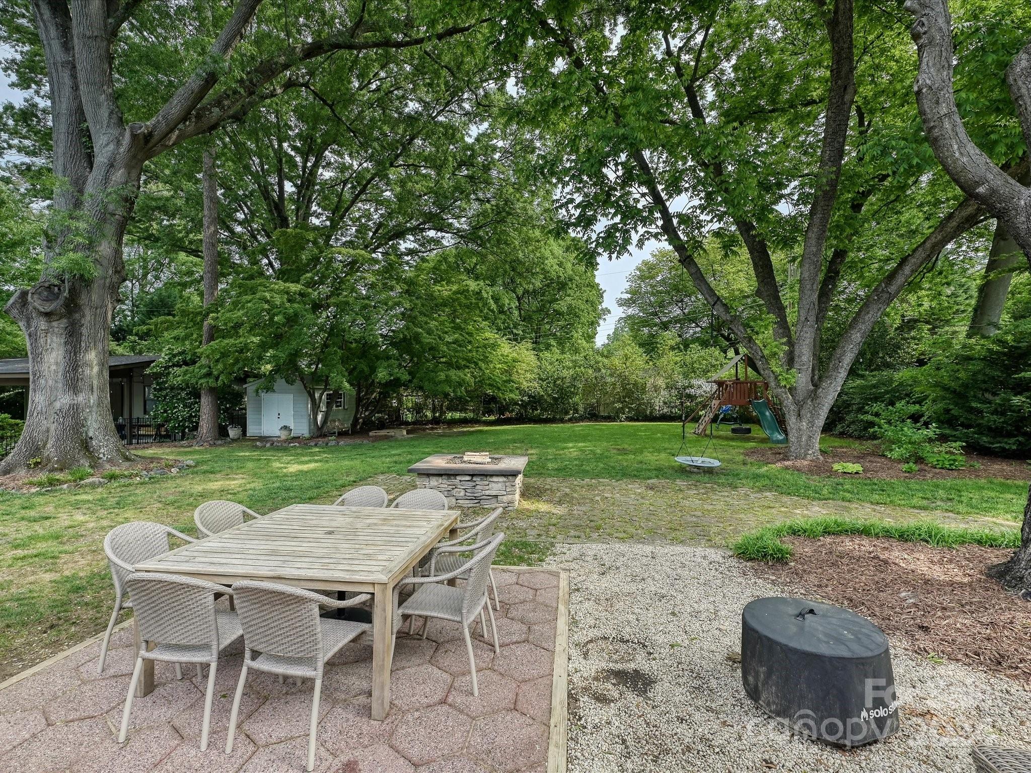 3401 Eastburn Road Charlotte, NC 28210 - Photo 36 of 43 a view of a backyard with table and chairs under an umbrella