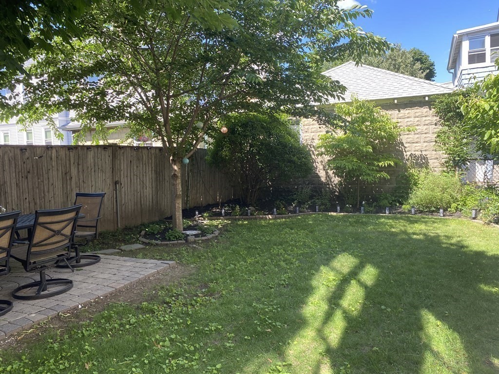 72 Everett Street Arlington, MA 02474 - Photo 3 of 25 a view of backyard with table and chairs and potted plants and large trees