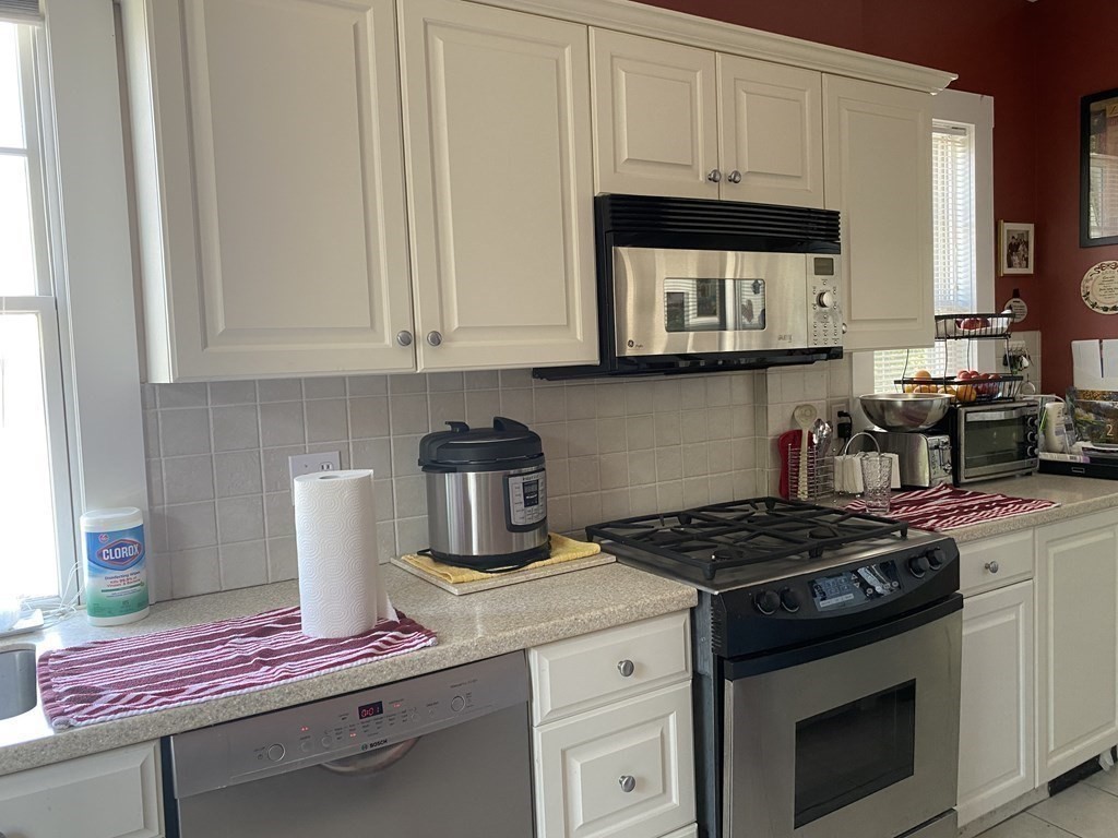 72 Everett Street Arlington, MA 02474 - Photo 6 of 25 a kitchen with granite countertop a stove and a white cabinets