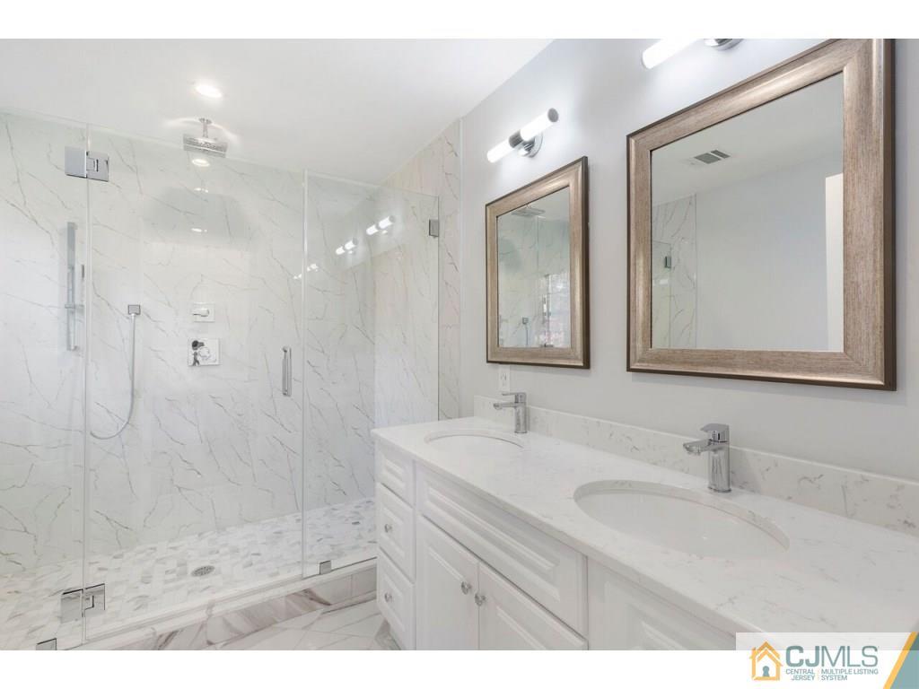 80 Lancaster Road Colonia, NJ 07067 - Photo 13 of 15 a bathroom with a double vanity sink mirror and shower