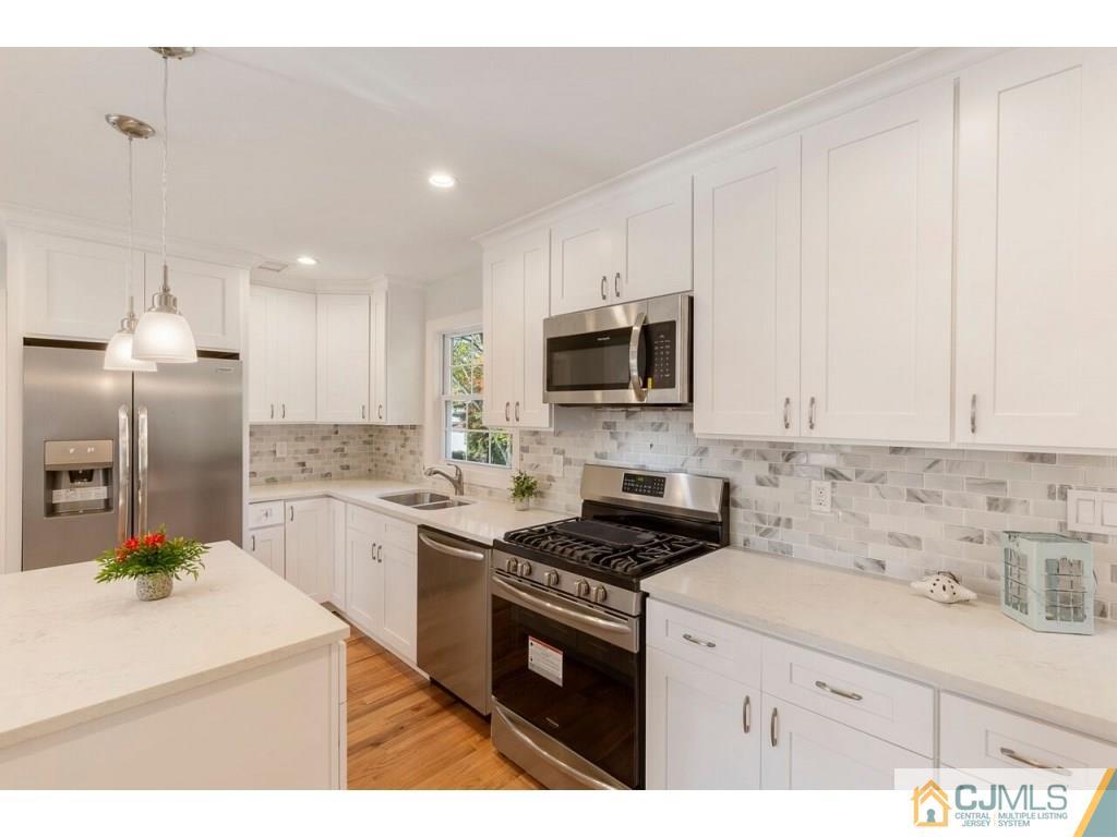 80 Lancaster Road Colonia, NJ 07067 - Photo 5 of 15 a kitchen with kitchen island a sink stainless steel appliances and cabinets