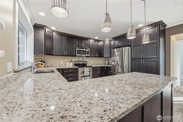 a kitchen with stainless steel appliances granite countertop a sink refrigerator and microwave