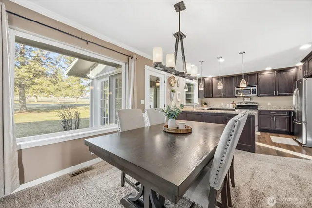 a view of a dining room and livingroom with furniture wooden floor a chandelier