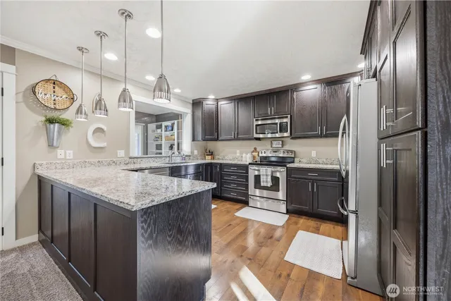 a kitchen with granite countertop stainless steel appliances a stove top oven a sink and a refrigerator